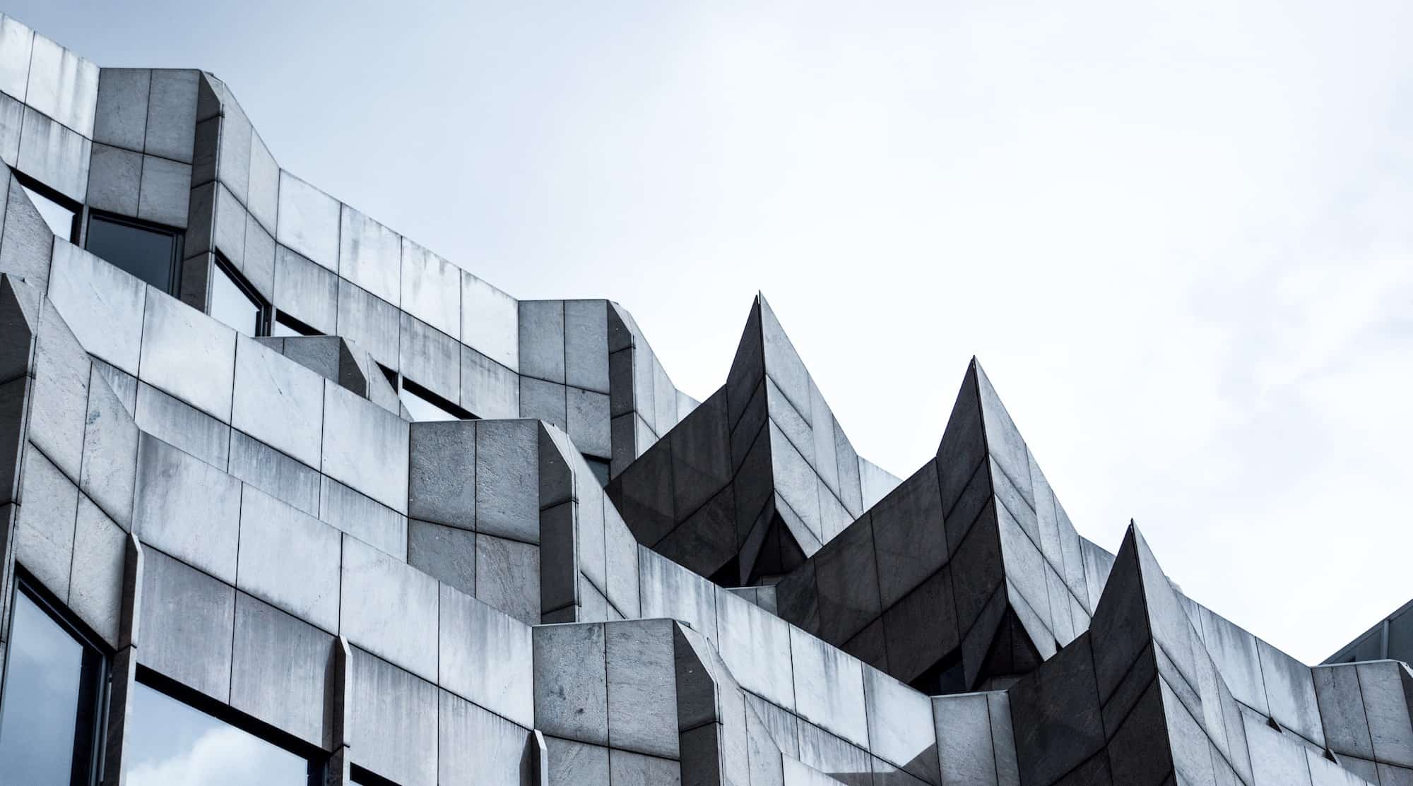 The top of a grey concrete building with a blue sky in the background